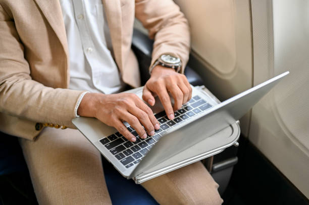 istock cropped, top view, A professional businessman using a laptop during the flight. 1449526986