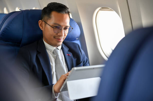 istock Professional businessman using digital tablet to check his meeting schedule during the flight. 1449527136