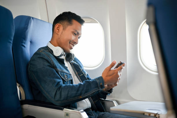 istock side view, Asian male passenger using his smartphone during the flight. 1449527297