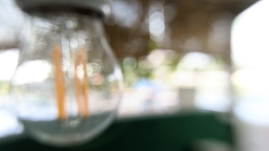 Close up of the glowing blurred vintage light bulbs at the cafe terrace. Can be used for background or display your product.