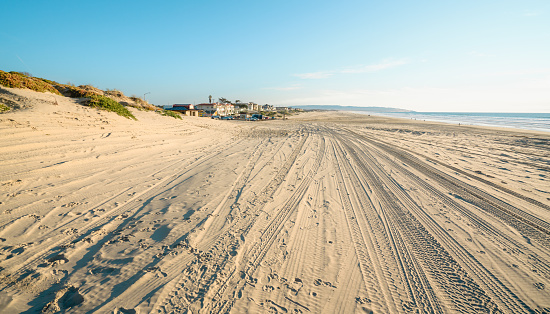 Oceano, California, USA -December 14, 2022. Tire tracks on sandy beach. Oceano Dunes Vehicular Recreational Aria, California State Park allows  vehicles to drive on the beach