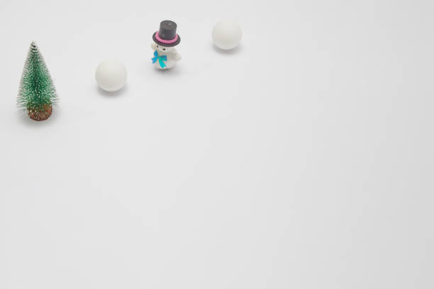 Snowman in the snow with two large snowballs with a black top hat, with copy space. Minimum winter snow composition.