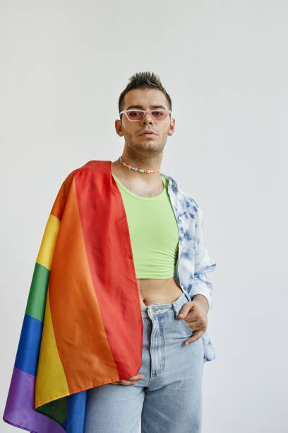 istock Young gay man draped with pride flag 1449531554