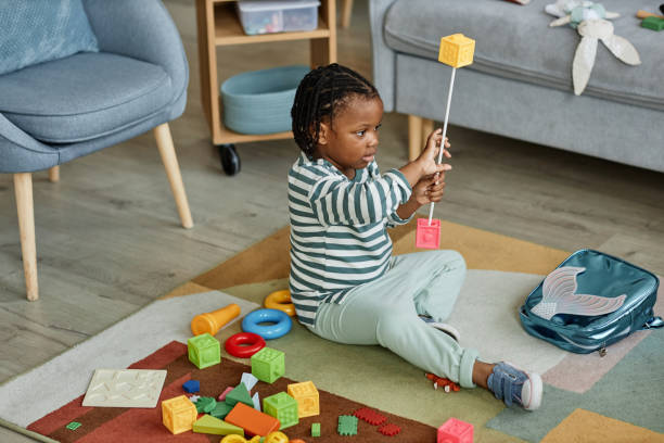 istock Black baby playing with toys on floor 1449533381