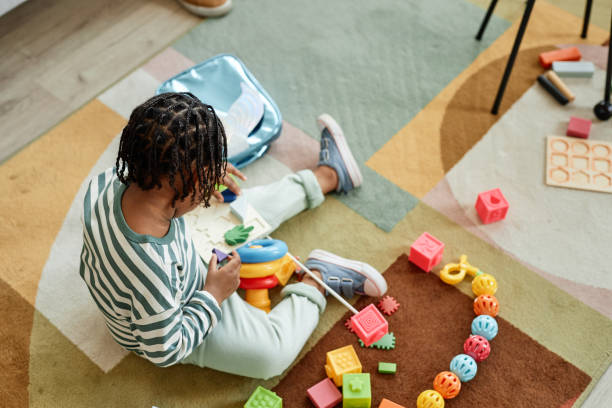 istock Boy playing with colorful toys on floor 1449533391
