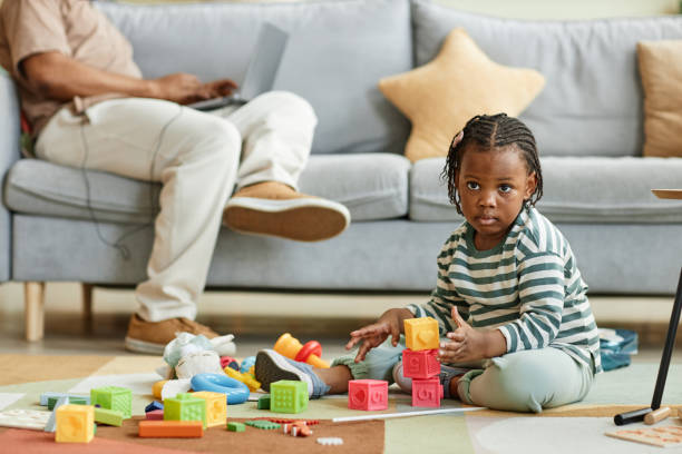 istock Cute black toddler playing with toy blocks 1449533396