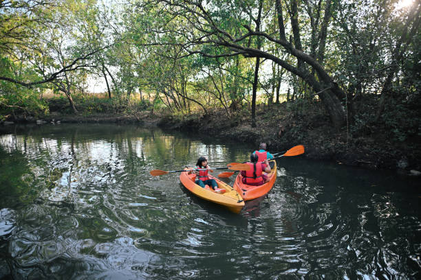 istock Small girl along with grandparents kayaking through forest river 1449534584