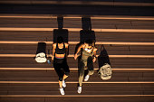 istock Two friend female athlete sitting on the steps and resting from running 1449535115