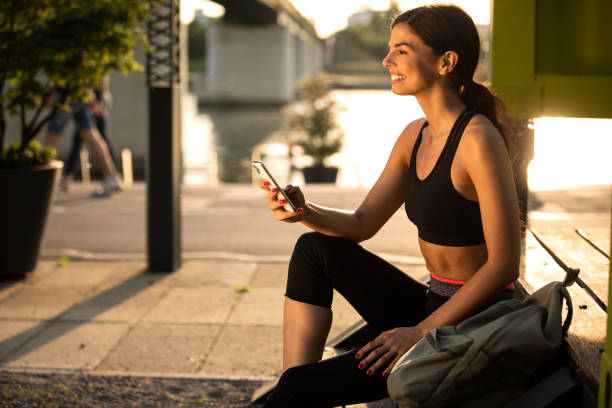 istock Young female sitting and typing message on the smart phone 1449536351
