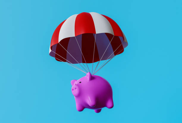 istock Piggy bank falling safely on a parachute against blue background 1449537461