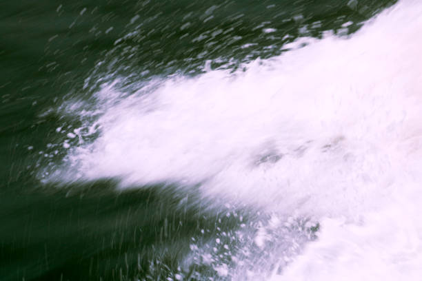 Close up of three water jets splashing into a freshly dyed green river in downtown Chicago after the annual tradition was restarted in 2021 for St. Patrick's Day holiday celebrations.