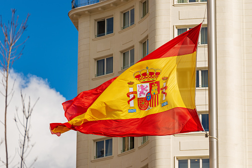 Closeup of a Spanish flag blowing in the wind in Spain Square (Plaza de Espana), Madrid downtown, Spain, southern Europe.