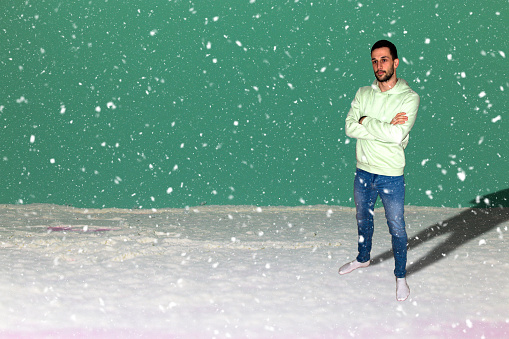 young man standing on snow, snowy day, white green snowy background, holiday time
