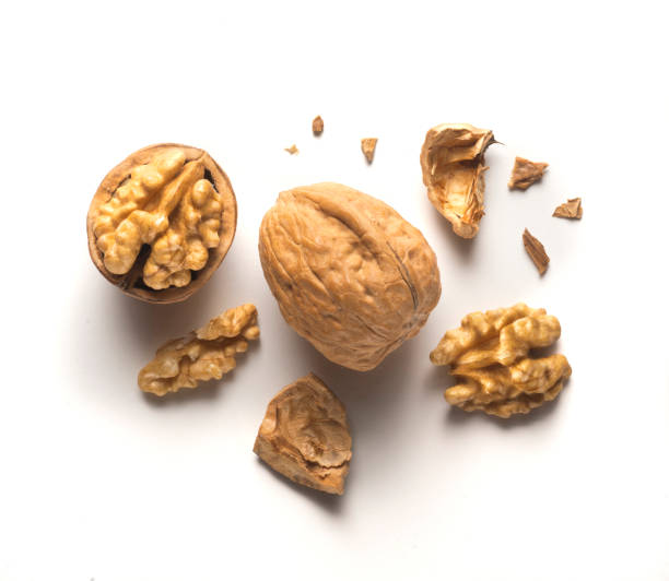istock whole walnut plus open walnut with scattered shell parts on white background 1449540249