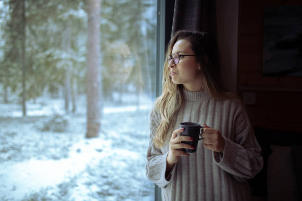 istock A woman drinks tea while looking out the window 1449540908