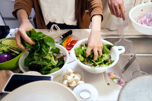 Closeup of couple's hands cooking vegan food