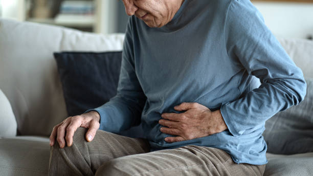 hombre mayor con dolor de estómago - estreñimiento fotografías e imágenes de stock