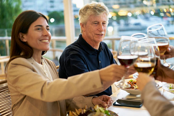 istock Corporate colleagues enjoying celebratory toast over dinner 1449544531