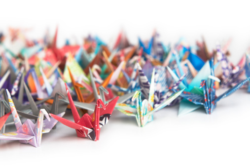 A group of colourful origami birds on a white background