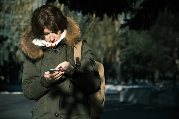istock Woman is using smart phone in winter town 1449546704
