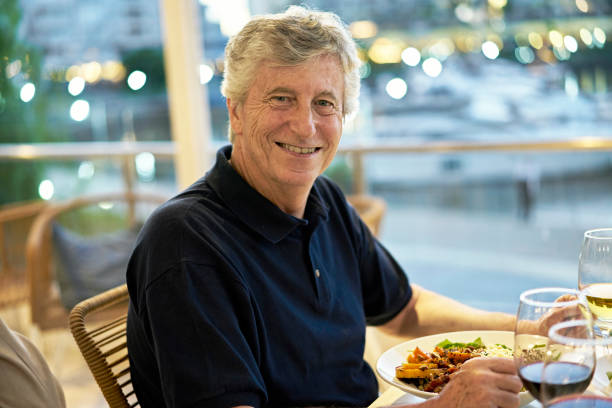 istock Senior man enjoying wine and evening meal at restaurant 1449547563