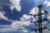 Electricity pylon (high voltage power line), black contour,  on the background of the cloudy sky