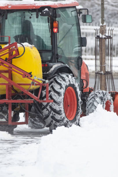 istock Tractor cleaning urban park paths on a cold snowy day. 1449549782