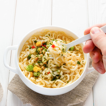 man eating noodles plastic fork