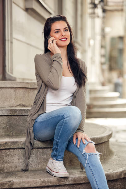 Young cute female using smartphone on the street.