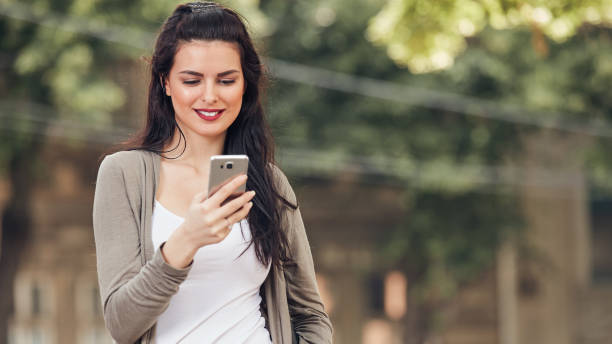 istock Young cute female using smartphone on the street. 1449550462