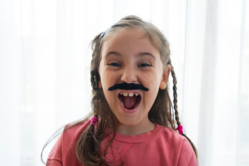 Portrait of a 6 year old wearing a moustache