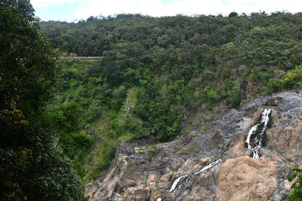 istock A waterfall cascading down rocks, with a train in the distance. 1449551741