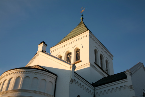 A white Norwegian church shining in the morning sun.