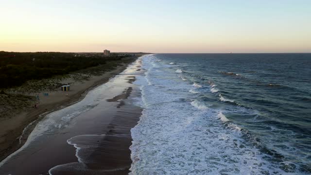 Aerial shot of the waves breaking at Rehoboth Beach, Delaware at sunset