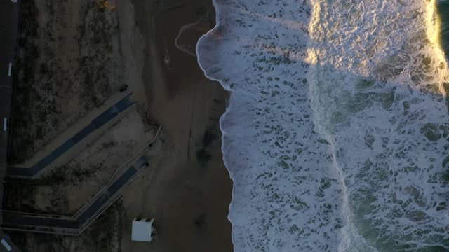 Aerial shot of the waves breaking at Rehoboth Beach, Delaware at sunset