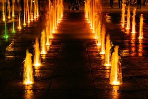 City fountain with orange neon lights.