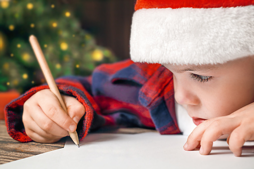 close-up of a child writing a letter to Santa Claus