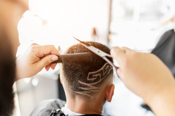 парикмахерская для бритья в волосах клиентов, держащих ножницы - men hairdresser human hair hairstyle стоковые фото и изображения