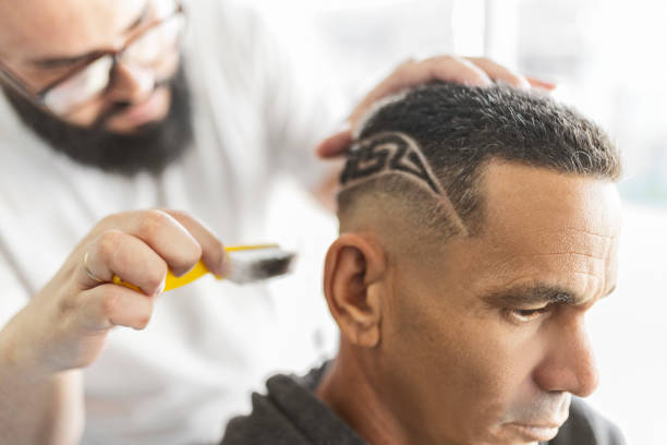 istock Barber brushing designs shaved on a clients hair 1449561658