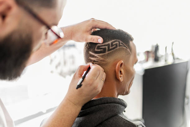 istock Barber drawing designs into a clients hair with pencil 1449561664