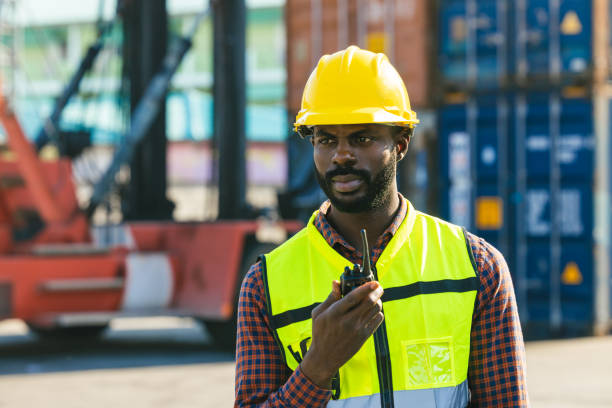 istock Logistics industry African black male engineer staff worker foreman at port container yard control loading cargo 1449568526