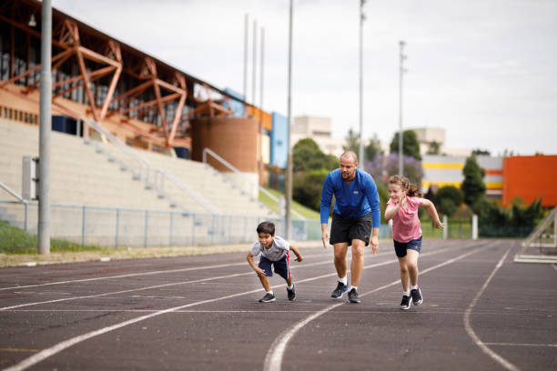 istock Kids having fun sprinting on the field with their dad 1449569832