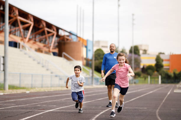istock Kids having fun sprinting on the field with their dad 1449569838