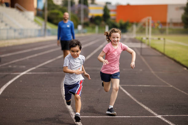 istock Father looking his kids sprint on the running field 1449569848