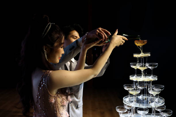 Chinese Wedding An Asian couple smiling joyfully during Chinese wedding banquet during champagne toast. chinese wedding dress stock pictures, royalty-free photos & images