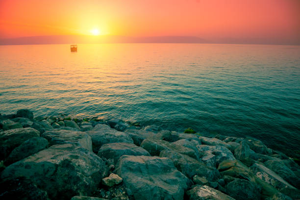 日の出時のガリラヤ湖の岩だらけの海岸 - lake tiberius ストックフォトと画像