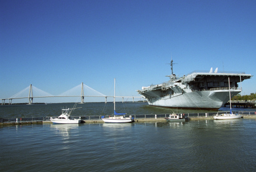 The World War II era aircraft carrier USS Yorktown, docked in the Charleston, SC Harbor with the Cooper River Bridge in the background.