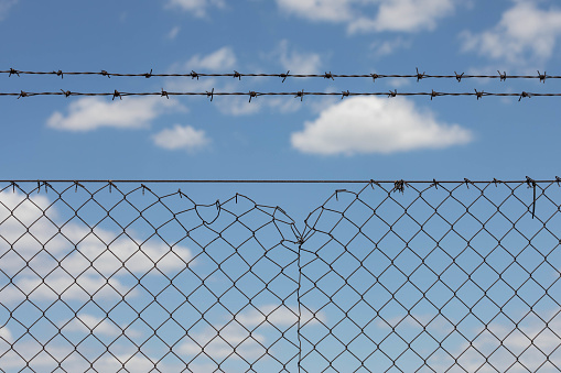 Blue Sky And White Clouds Behind The Barbed Wire, No Freedom Concept