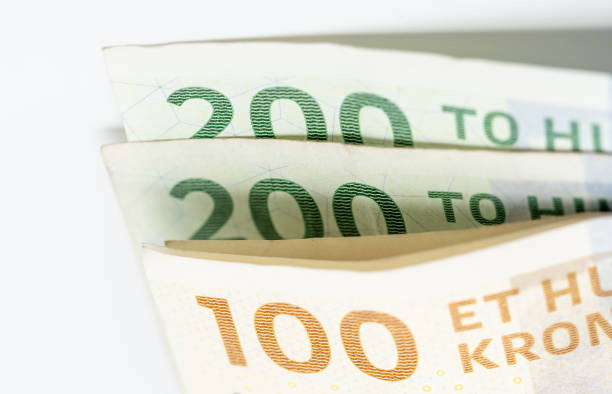 Close-up of a stack of yellow and green banknotes of 100 kroner and 200 kroner. In focus the denominations of the banknotes. The banknotes belong to the current 2009 series issued by the Danish National Bank (Danmarks Nationalbank).