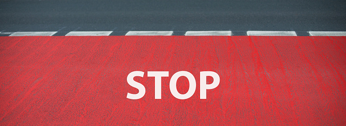 Stop is standing on the road, warning sign, take caution, finish line for a runner on the asphalt, sport concept